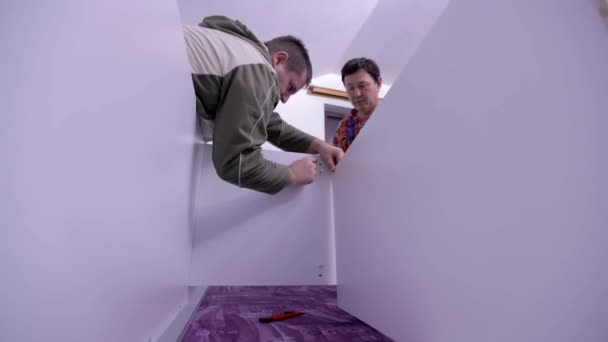 Los hombres están montando muebles nuevos — Vídeo de stock