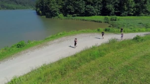 Een paar mensen lopen langs het meer — Stockvideo