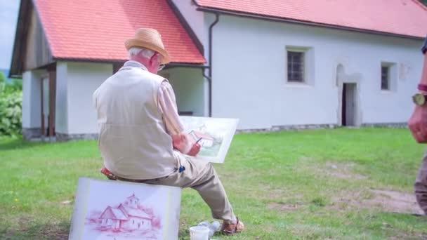 Wandelaars komen op de top van de heuvel waar de kunstenaar is tekening — Stockvideo