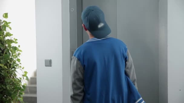 Jeune en attente de l'arrivée d'un ascenseur 