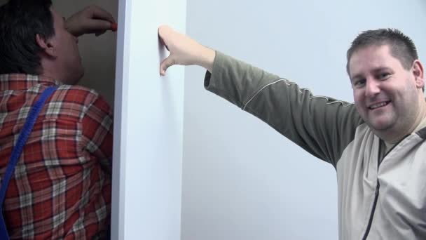 Männer bauen neue Garderobe auf — Stockvideo