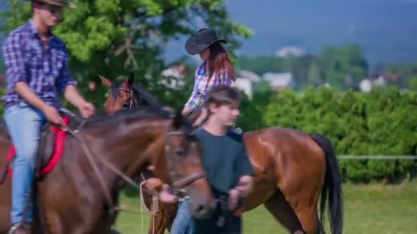 Casal está andando seus cavalos em círculos — Vídeo de Stock