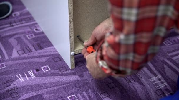 Hombre usando el destornillador muebles de montaje blanco — Vídeos de Stock