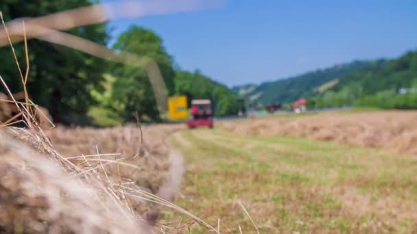 El tractor está cosechando heno en un campo — Vídeo de stock