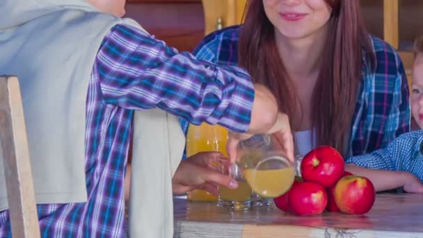 Familia está sentada detrás de la mesa — Vídeos de Stock