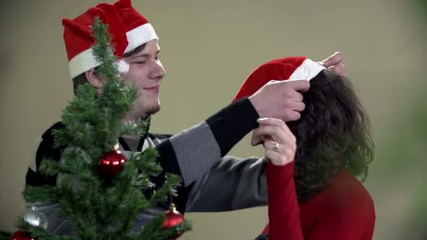 Kerl setzt Weihnachtsmann auf den Kopf von Mädchen — Stockvideo