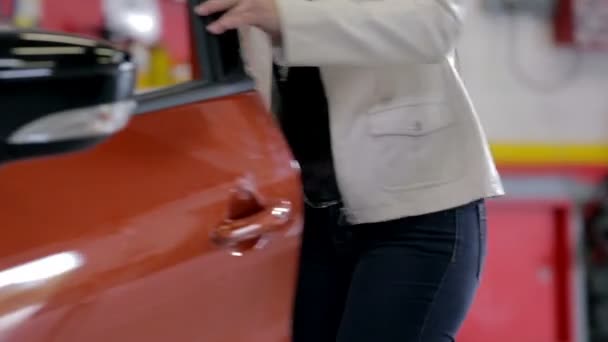 Mujer entrando coche rojo — Vídeos de Stock