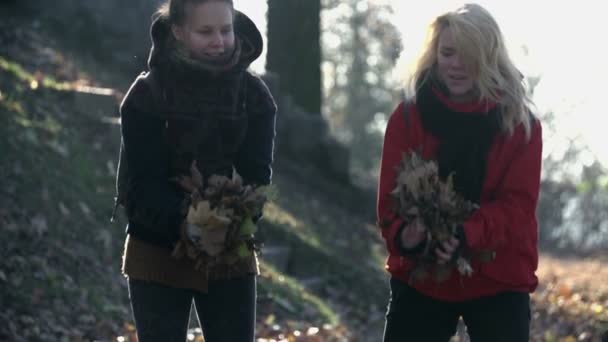 femmes jetant des feuilles d'automne 
