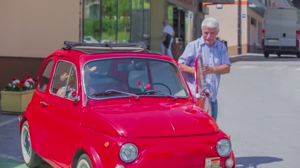 Um casal mais velho está saindo de um yugo vermelho — Vídeo de Stock