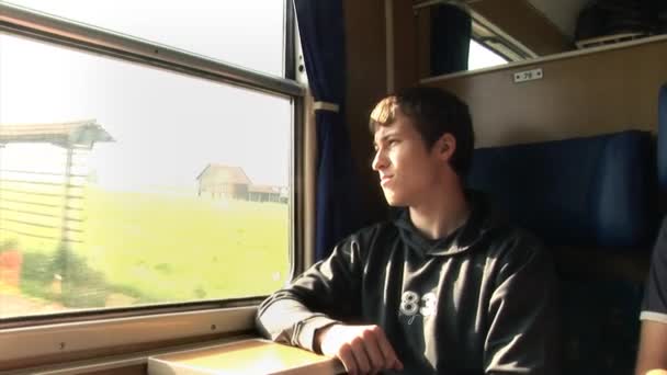 Ragazzo che viaggia in treno e guarda attraverso la finestra — Video Stock