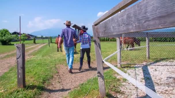 Casal está andando para os estábulos de equitação — Vídeo de Stock