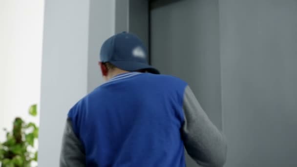 Jeune en attente de l'arrivée d'un ascenseur 