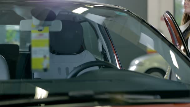 Mujer entrando coche rojo — Vídeo de stock