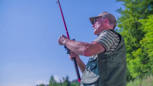 Pescador está pescando en el lago — Vídeos de Stock