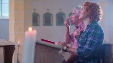 Christians opening the Bible and crossing themselves