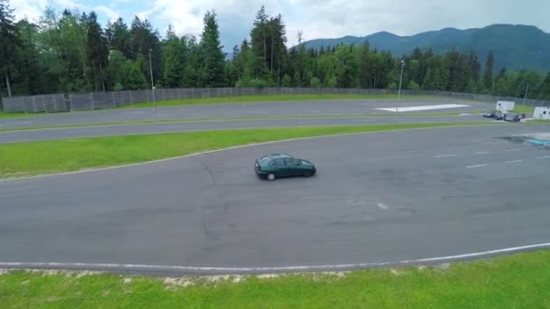 Auto die door middel van de veelhoek met asfalt cursussen rijdt — Stockvideo