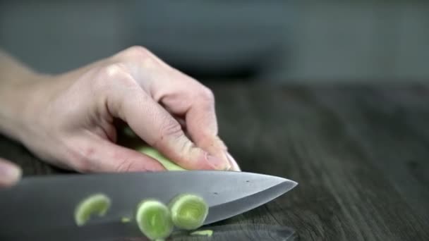 Жінка вирізає цибулю-порей — стокове відео