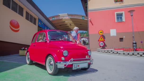 An older couple is coming out of a red yugo — Stock Video