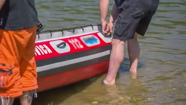 Los hombres están empujando su bote de goma en el agua — Vídeos de Stock