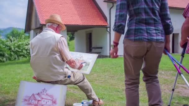 Hikers are coming on top of the hill where the artist is drawing — Stock Video