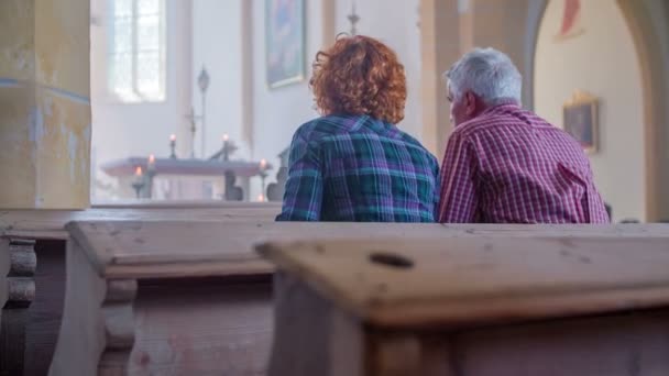 Christen setzen sich in Kirchenbänke und kreuzen sich — Stockvideo