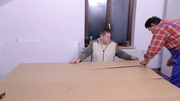Los hombres están montando muebles nuevos — Vídeo de stock