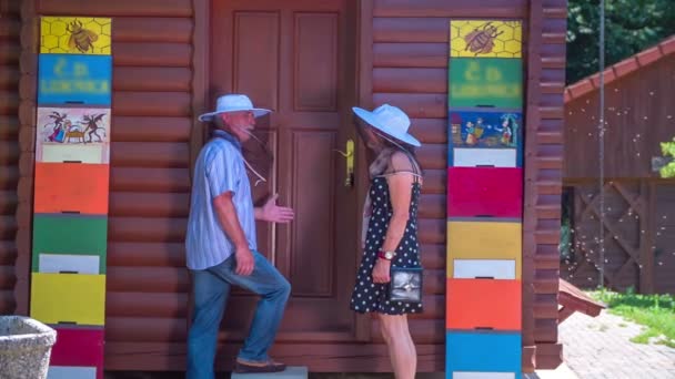 Een ouder echtpaar staat tegenover een bijenschuur — Stockvideo