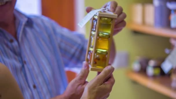 Man is putting jars with honey on a shelf — Stock Video