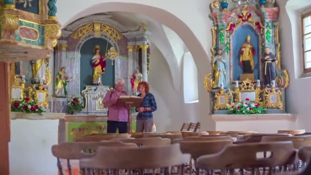 Folk besöker insidan av kyrkan — Stockvideo