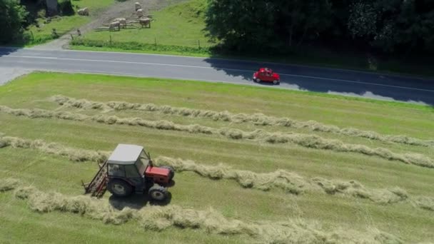 Coche está conduciendo en una carretera de campo y pasando un tractor — Vídeo de stock
