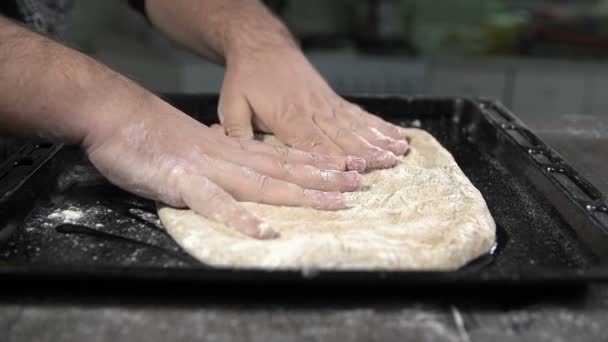 Человек кладет тесто — стоковое видео