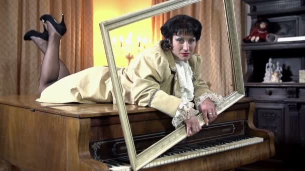 Female on the piano and holding picture frame — Stock Video