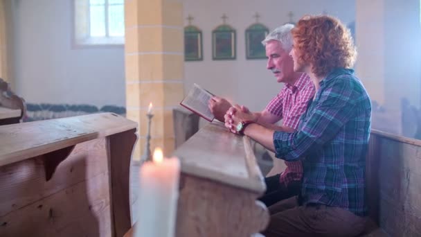 Pareja mayor leyendo y mirando la Biblia — Vídeo de stock