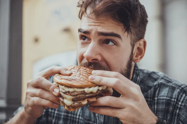 Mužské jíst hamburger — Stock fotografie