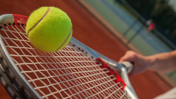 Hráč na ruce s tenisovou raketu a míček — Stock fotografie