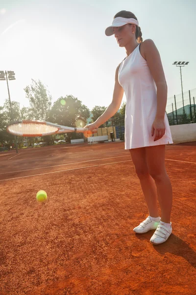 Atractiva jugadora de tenis femenina golpeando una pelota — Foto de Stock