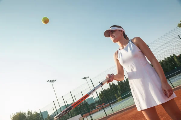 Atraente jogador de tênis feminino batendo uma bola — Fotografia de Stock