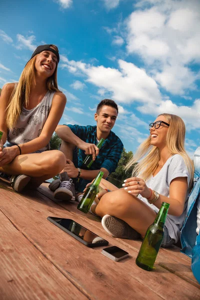 Vrolijke vrienden koelen in de buurt van Lake — Stockfoto