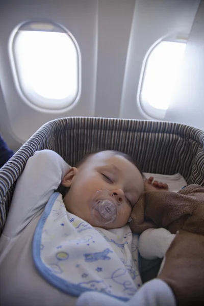 Bebé niño durmiendo en bassinet en avión — Foto de Stock