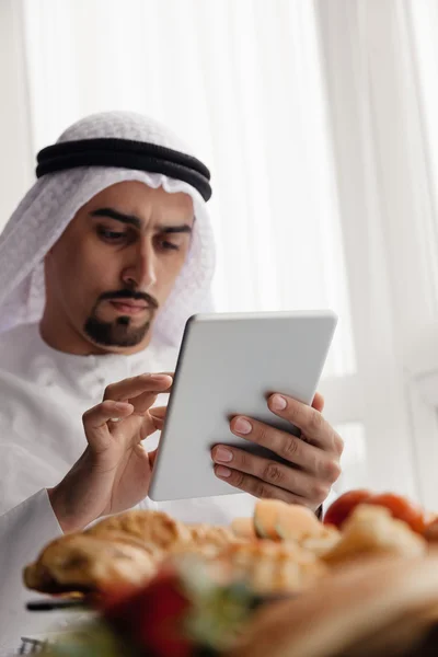 Arap erkek tablet kahvaltı sırasında kullanma — Stok fotoğraf