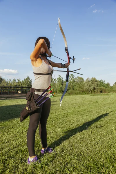 Mujer practicando tiro con arco — Foto de Stock
