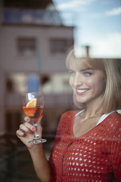 Mooie vrouw u geniet van uitzicht vanuit haar appartement — Stockfoto