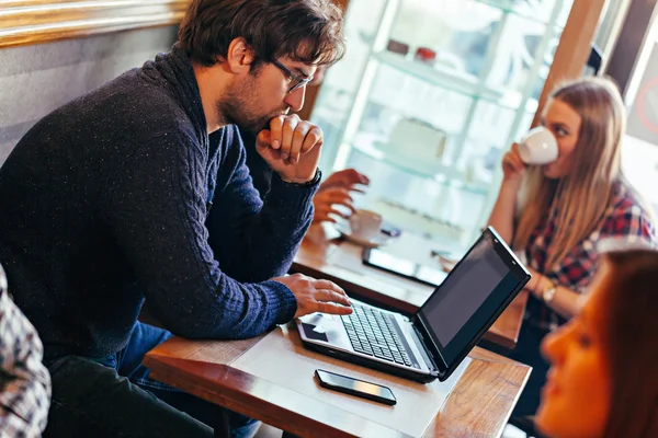 Jonge man met laptop in cafe — Stockfoto