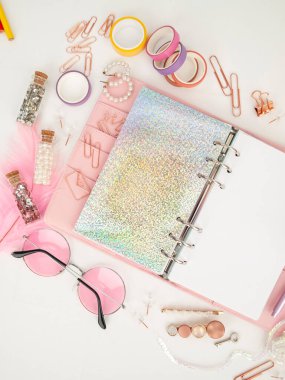 Günlük beyaz ve holografik sayfa ile açılır. Şirin kırtasiye malzemesi olan pembe planlamacı düz açılı fotoğraf çekiyor. İş kırtasiyeli pembe planlayıcının en iyi görüntüsü. Dekorasyon kırtasiyeli Pembe Cazibeli planlayıcı