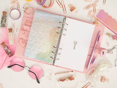 Anahtar, planlayıcının beyaz sayfasında. Günlük beyaz ve holografik sayfa ile açılır. Şirin kırtasiyeli pembe planlamacı. Kırtasiyeli pembe planlayıcının üst görüntüsü. Pembe cazibe planlayıcı dekorasyonu