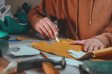 Shoemaker 'ın atölyesindeki deri bıçakla kesim kalıplarını kapatın..