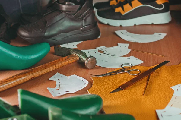 Close up of shoemaker tools on the table in workshop.