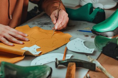 Shoemaker atölyesindeki deri bıçakla şablon kesiyor..