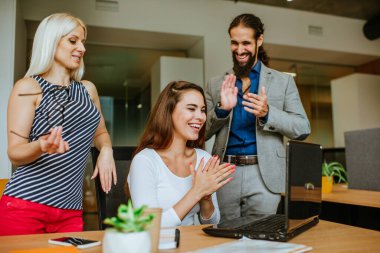 İş arkadaşları ofisteki sorunu çözdüğü için iş kadınını tebrik ediyor.