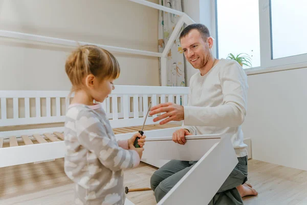 Vater mit Tochter repariert Schublade im Kinderbett — Stockfoto